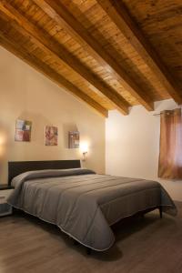 Asaro Camere في Campobello di Licata: غرفة نوم بسرير كبير في غرفة بسقوف خشبية