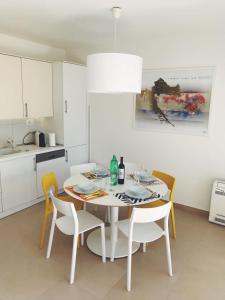 a white kitchen with a dining room table and chairs at SiMa in Baška Voda