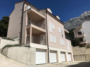 a building with two garage doors in front of a mountain at SiMa in Baška Voda