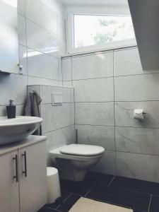 a bathroom with a toilet and a sink and a window at SiMa in Baška Voda +28 photos