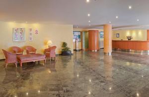 a lobby with a table and chairs in a building at TRH Jardín Del Mar in Santa Ponsa