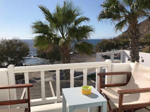 a balcony with chairs and a table and a view of the ocean at Oklacà Patmos Beach Rooms in Patmos