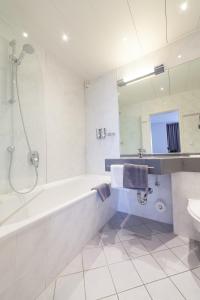 City-Hotel garni في نوي-أولم: حمام أبيض مع حوض ومغسلة