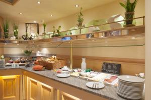 a buffet line in a restaurant with plates and dishes at City-Hotel garni in Neu-Ulm