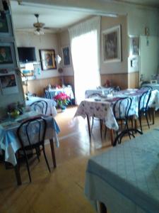 una sala da pranzo con tavoli e sedie in una stanza di Pensione Santachiara a Sanremo