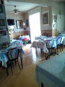 a dining room with tables and chairs in a room at Pensione Santachiara in Sanremo +10 photos