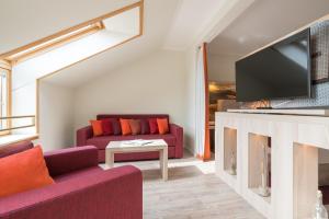 a living room with a couch and a tv at Hotel Garni Kölfhamm in Sankt Peter-Ording