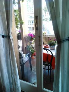 Une porte ouverte s'ouvre sur une terrasse avec une table et des chaises. dans l'établissement Pensione Santachiara, à Sanremo