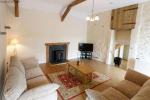 a living room with a couch and a fireplace at Brynheulwen in Llanilar