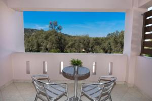 a dining room with a table and chairs and a large window at Alexandros in Lefkada Town