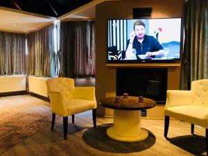 uma sala de estar com uma televisão e uma mesa e cadeiras em Velena Hotel em Ağva