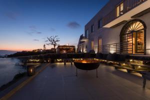 - un bâtiment avec une terrasse dotée d'un foyer extérieur la nuit dans l'établissement White Exclusive Suites & Villas, à Lagoa