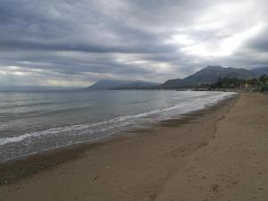 una playa con un cielo nublado y el océano en B&B A casa dell'artista, en Casteldaccia