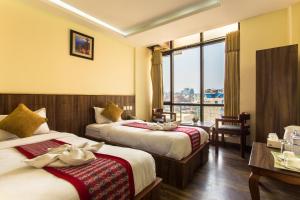 カトマンズにあるHotel Kathmandu Innのベッドが2つと窓があるホテルの部屋 +43枚の写真