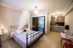 a bedroom with a bed and a table and a kitchen at Alexandros in Lefkada