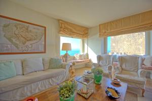 a living room with white couches and a table at Presidio by PosarelliVillas in Fonteblanda