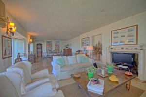 a living room with white furniture and a fireplace at Presidio by PosarelliVillas in Fonteblanda