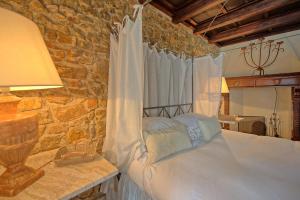 a bedroom with a bed and a stone wall at Presidio by PosarelliVillas in Fonteblanda