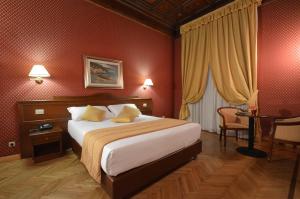 a bedroom with a large bed with red walls at Hotel Montecarlo in Rome