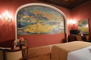 a bedroom with a large painting on the wall at Hotel Montecarlo in Rome