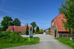 a village with a windmill in the middle of a street at Ferien- und Reiterparadies Voßhörnerhof in Neuschoo