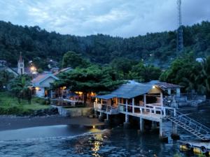 a resort on the water at night at Cocotinos Lembeh a Boutique Dive Lodge in Bitung