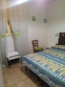 - une chambre avec un lit et une chaise dans l'établissement Pensione Santachiara, à Sanremo