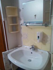 une salle de bain avec un lavabo blanc et un miroir dans l'établissement Pensione Santachiara, à Sanremo 10 autres photos