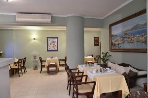 a restaurant with tables and chairs and a painting on the wall at Ikaros Art Hotel in Agios Nikolaos