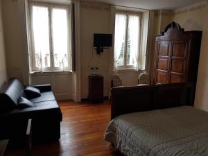 a bedroom with a bed and a couch and windows at Alla Torretta in Bellagio