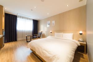Postel nebo postele na pokoji v ubytování Reborn Suwon Silkroad Hotel
