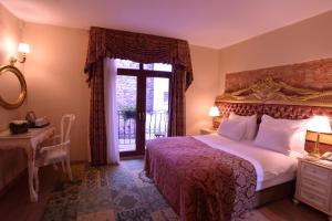 a bedroom with a bed and a desk and a window at By Murat Royal Hotel Galata in Istanbul
