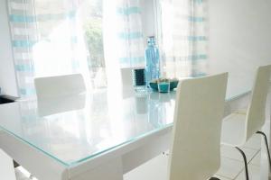 セリにあるDisneyLand Zénitudeのガラステーブル(白い椅子2脚付)、ボトル1本