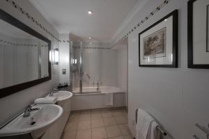 a bathroom with two sinks and a shower and a tub at The Westmead Hotel in Hopwood