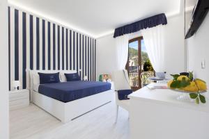 a bedroom with a bed with blue sheets and a table at Villa Iolanda in Piano di Sorrento