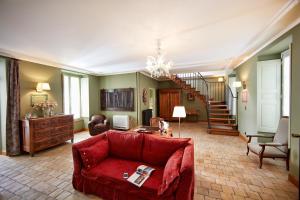 ein Wohnzimmer mit einem roten Sofa und einer Treppe in der Unterkunft Le Clos Sainte-Marguerite in Beaune