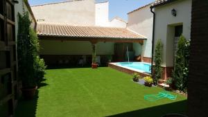 un patio con piscina y una casa en Casa Rural Doña Elisa, en Torrenueva