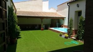 a yard with a swimming pool and a house at Casa Rural Doña Elisa in Torrenueva