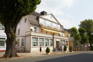 a woman walking in front of a building at HotelHaus Ritter in Bad Pyrmont