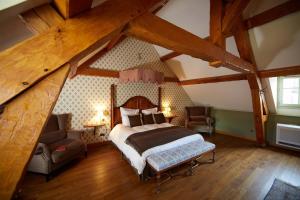 a bedroom with a bed and two chairs in a attic at Le Clos Sainte-Marguerite in Beaune