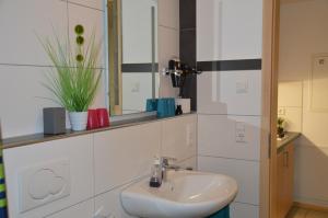 a bathroom with a sink and a mirror at Ferienwohnung Am Brunnen (Nähe Europapark) in Rheinhausen