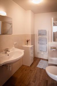 a white bathroom with a sink and a toilet at Oberhof Weitental in Vallarga