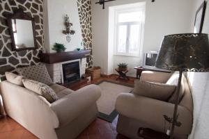 sala de estar con 2 sofás y chimenea en Casa da Fonte Nova, en Lousã