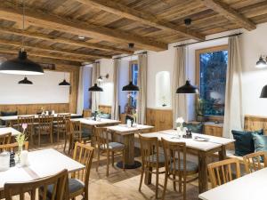 un restaurante con mesas y sillas de madera y ventanas en Stefanies-Café-Pension-Kultur, en Bad Feilnbach