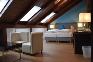 1 Schlafzimmer mit 2 Betten, einem Schreibtisch und einem Stuhl in der Unterkunft Atel Hotel Lasserhof in Salzburg