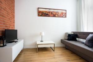 uma sala de estar com um sofá e uma televisão em Apartament Felicjanek em Cracóvia