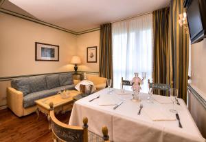ein Hotelzimmer mit einem Tisch und einem Sofa in der Unterkunft DB Villas Le Ville del Lido Resort in Lido di Venezia
