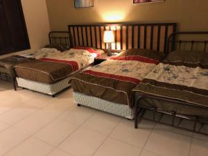 pokój z 3 łóżkami w pokoju z lampką w obiekcie Gold Coast Morib w mieście Morib