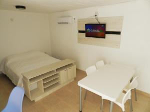 a bedroom with a bed and a table and chairs at Alta Patagonia Apart in Viedma