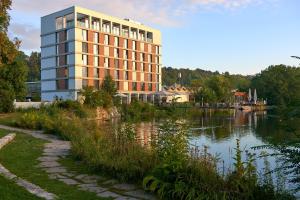 a building next to a body of water at LAGO hotel & restaurant am see in Ulm